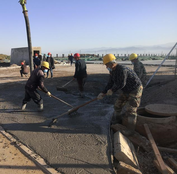 宝鸡蟠龙新区污水处置惩罚厂项目施工职员对厂区蹊径面层举行混凝土浇筑作业_副本.jpg